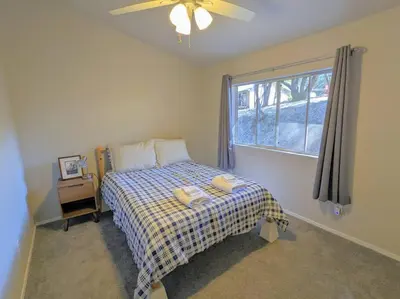 a bedroom with a bed with a plaid blanket and a window at Home in Groveland near Yosemite NP in Groveland