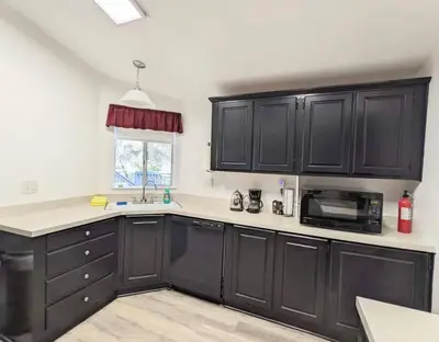 a kitchen with black cabinets and a microwave at Home in Groveland near Yosemite NP in Groveland