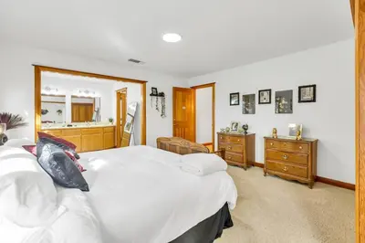 a bedroom with a large white bed and a mirror at Lakeside Vineyard Retreat - Deaver's Winery in Plymouth