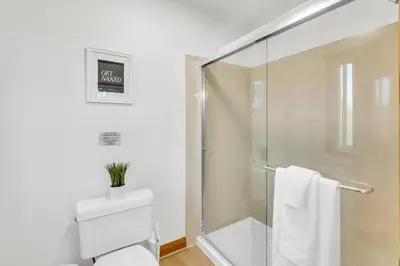 a bathroom with a glass shower and a toilet at Lakeside Vineyard Retreat - Deaver's Winery in Plymouth