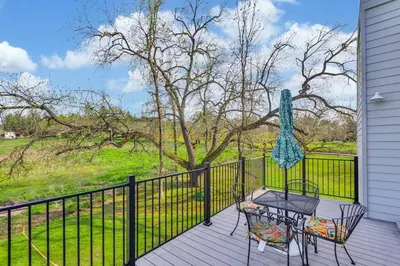 a balcony with a table and chairs and a fence at Lakeside Vineyard Retreat - Deaver's Winery in Plymouth