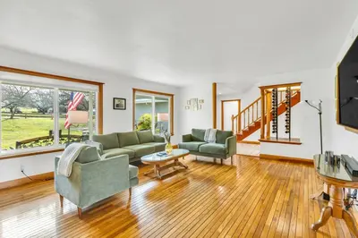 a living room with two couches and a table at Lakeside Vineyard Retreat - Deaver's Winery in Plymouth