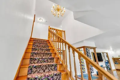 a staircase in a home with a chandelier at Lakeside Vineyard Retreat - Deaver's Winery in Plymouth