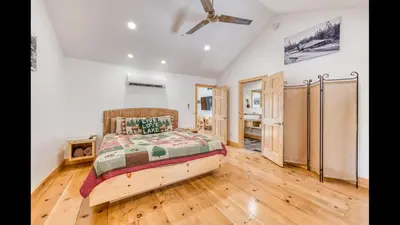 a bedroom with a bed and a wooden floor at #2 Cottage Like Suite With Private Hot Tub in Bass Lake