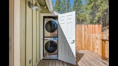 an open door to a house with a washing machine at #2 Cottage Like Suite With Private Hot Tub in Bass Lake
