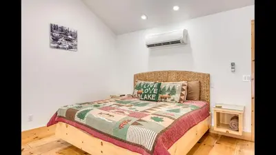 a bedroom with a bed with a quilt on it at #2 Cottage Like Suite With Private Hot Tub in Bass Lake