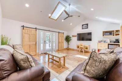 a living room with a couch and a table at #3 Cottage Like Suite With Private Hot Tub in Bass Lake