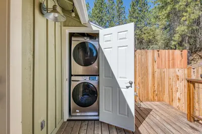 an open door to a house with a washer and dryer at #4 Cottage Like Suite with Private Hot Tub in Bass Lake