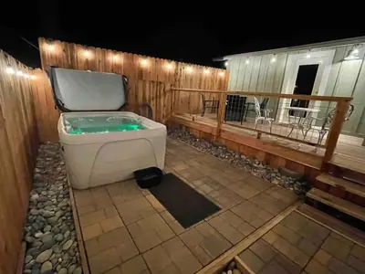 a bath tub sitting on top of a patio at #4 Cottage Like Suite with Private Hot Tub in Bass Lake