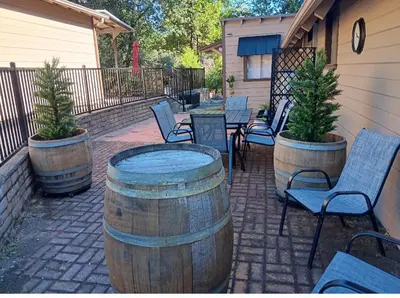 a patio with tables and chairs and trees in barrels at Knotty Pines Lodge in Bass Lake Annex