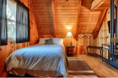 a bedroom with a bed in a wooden cabin at Knotty Pines Lodge in Bass Lake Annex