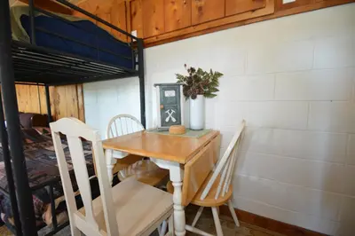 a table and chairs in a room with a bunk bed at Fox Lake View in Bass Lake