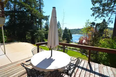 a table with an umbrella on a deck at Fox Lake View in Bass Lake