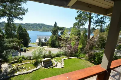 a balcony with a view of a garden and a lake at Fox Lake View in Bass Lake