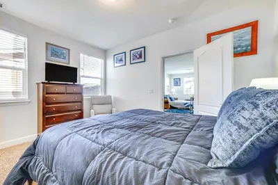 a bedroom with a bed and a dresser with a tv at WWII Aviation-Themed Apt in Sparks Near Parks! in Sparks