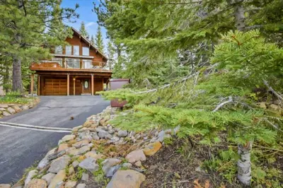 a large house with a driveway and trees at Incline Village Getaway in Incline Village