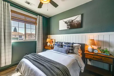 a bedroom with a bed with a cow picture on the wall at Enchanting Clovis Haven with Hot Tub and Private Pool! in Clovis