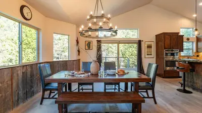 a dining room with a wooden table and chairs at 10mins to Lake • Hot Tub Game Room Forest Views Meyers Meadow by AvantStay in South Lake Tahoe