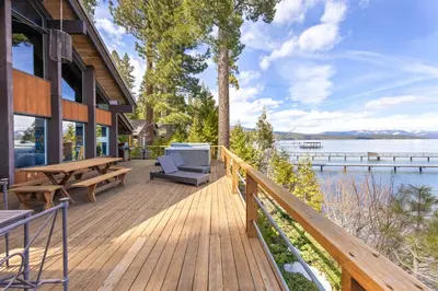 a wooden deck with a bench and a table at Towering Pines Lakefront - 3 BR w Hot Tub & Buoy in Tahoe City