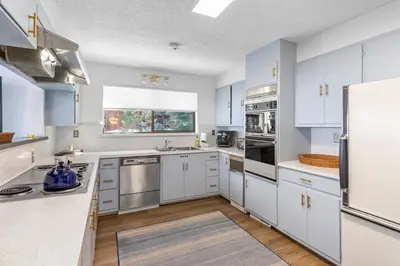 a kitchen with white cabinets and stainless steel appliances at Towering Pines Lakefront - 3 BR w Hot Tub & Buoy in Tahoe City