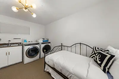 a bedroom with a bed and a washing machine at Towering Pines Lakefront - 3 BR w Hot Tub & Buoy in Tahoe City