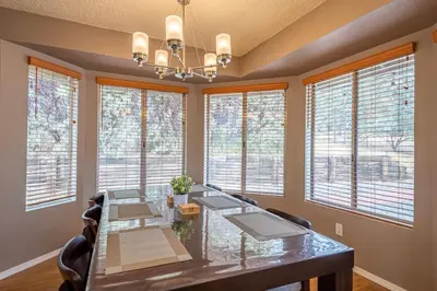a dining room with a table and windows at Royal Arches Cottages in Oakhurst