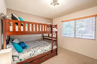 a bedroom with two bunk beds and a window at Royal Arches Cottages in Oakhurst