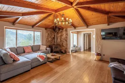 a living room with a couch and wooden ceilings at Royal Arches Cottages in Oakhurst