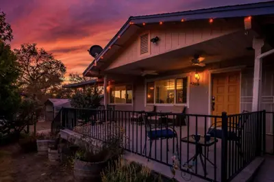 a house with a porch with a sunset at Royal Arches Cottages in Oakhurst
