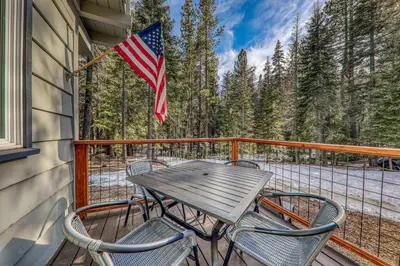 a table and chairs on a balcony with an american flag at 3BD Retreat - 5 Min to Beach Trails & Town in Carnelian Bay