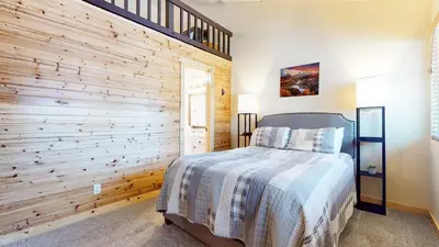 a bedroom with a wooden accent wall and a bed at Sierra Park Road #150 condo in Mammoth Lakes