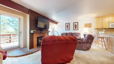 a living room with two chairs and a fireplace at Lakeview Villas #27 condo in Mammoth Lakes