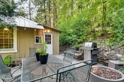 a backyard patio with a grill and a house at 8 Mi to Yosemite National Park Cabin with Fire Pit in Oakhurst