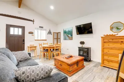 a living room with a couch and a table at Cozy Cottage with Park Pass, 1 Mi to Jenkinson Lake! in Pollock Pines