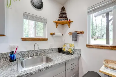 a kitchen with a sink and a christmas tree on the counter at Cozy Cottage with Park Pass, 1 Mi to Jenkinson Lake! in Pollock Pines