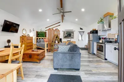 a kitchen and living room with a couch and a table at Cozy Cottage with Park Pass, 1 Mi to Jenkinson Lake! in Pollock Pines