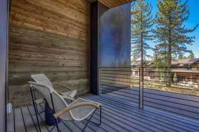 two chairs on a wooden porch with trees in the background at Crestwood at Schaffer's Mill in Truckee