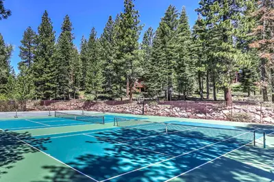 two tennis courts with trees in the background at 1 Mi to Lake Tahoe Condo with Pool Access in Kings Beach