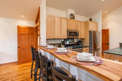 a kitchen with a large wooden island with chairs at Northstar - Northstar Vista in Truckee