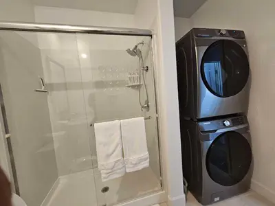 a bathroom with a shower and a washing machine at Couple's Getaway Kitchenette Washer & Private Bath in Lincoln Village