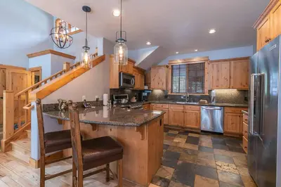 a large kitchen with wooden cabinets and a large island at The Cottages - Ski Shuttle, Ski Valet - 3-Bedroom in Truckee