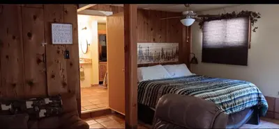 a bedroom with a bed and a chair in a room at 1948 Cottage with today's amenities in Bass Lake Annex