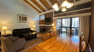 a living room with a couch a table and a fireplace at Lakeland Village 403 - Beach Peak Retreat in South Lake Tahoe