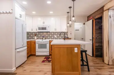 a kitchen with white appliances and wooden cabinets at Fully Renovated! St Anton #17 Ski in Ski Out 1 Bedroom 1 Bathroom Condo! Sleeps up to 4! in Mammoth Lakes