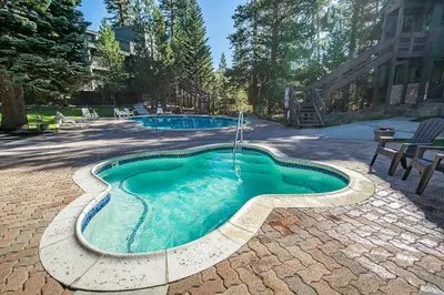 a small swimming pool with blue water in a yard at Fully Renovated! St Anton #17 Ski in Ski Out 1 Bedroom 1 Bathroom Condo! Sleeps up to 4! in Mammoth Lakes