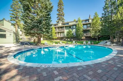 a swimming pool in front of a building at Fully Renovated! St Anton #17 Ski in Ski Out 1 Bedroom 1 Bathroom Condo! Sleeps up to 4! in Mammoth Lakes