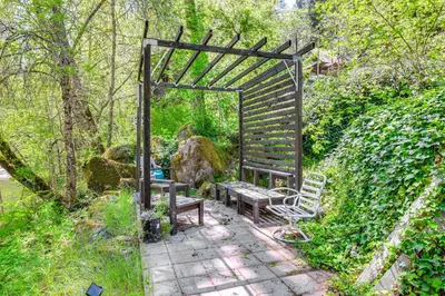 a garden with a bench and a wooden pergola at On-Site River Access Quiet Home in Wilseyville! in Wilseyville
