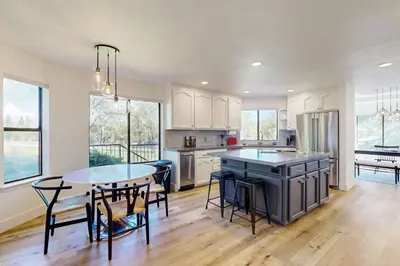 a kitchen with a table and chairs and a kitchen with white cabinets at Fair Days on the Fairway in Groveland