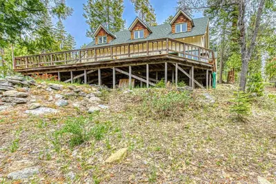 a large wooden house on top of a hill at Baxter Mountain Cottage in Shaver Lake