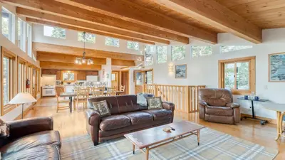 a living room with a couch and a table at Lake Beach Access Pool Tennis Walk to Chambers Tahoe Timber by AvantStay in Homewood